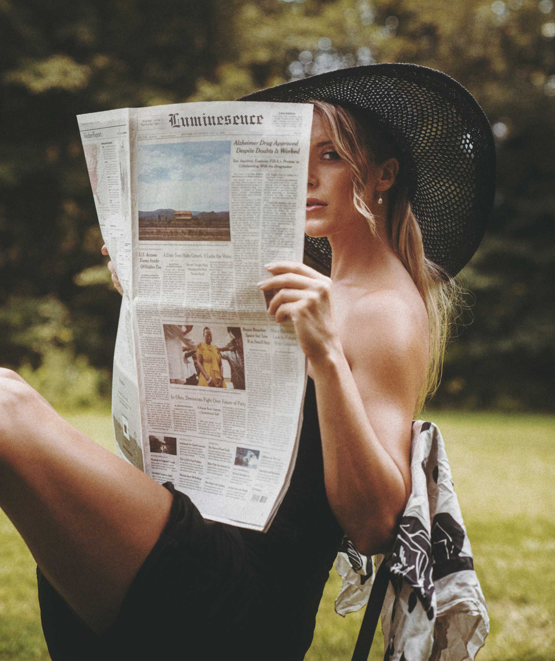 Woman reading the Luminescence newspaper in the park
